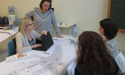 Participants d'une formation, analysant des plans avec une formatrice